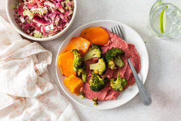 A nutritious morning meal featuring sweet potato, broccoli, radish salad with chia seeds and beet hummus for a balanced, protein-packed start