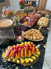 An assortment of savory buffet dishes including mini sandwiches, quiches, cheese platters, cold cuts, and canapés, beautifully arranged on a table