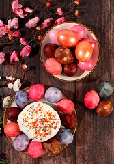 Easter celebration concept, traditional kulich and marble Easter eggs painted with onion peel, hibiscus tea and pink matcha with sakura branches, ideas for homemade Easter dishes.