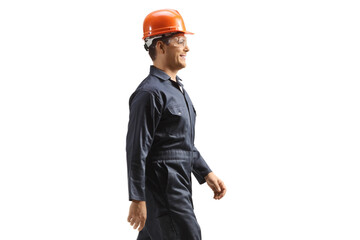 Factory worker wearing a helmet and uniform and walking