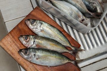 fresh fish on the chopping board in the kitchen 