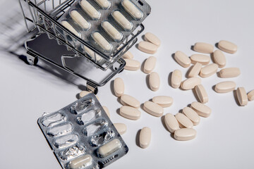 many tablets are scattered near the shopping cart, on which lies a pallet of medicines. medical concept