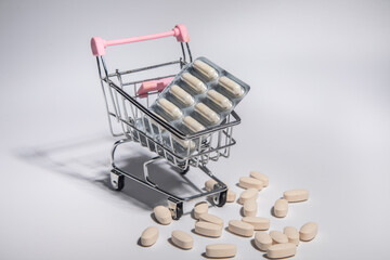 A pallet of medicine in a shopping cart, on a gray background. Healthcare and medical concept
