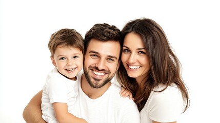 Happy family portrait against a white background. A young boy sits on his father's lap, while his mother stands beside