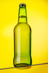 A cold beer bottle standing on a glass table