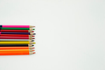 Pencils of pink, green, red, purple, gray, yellow colors on a white background