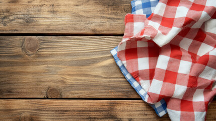 Obraz premium A checkered napkin neatly folded on a rustic wooden background, creating a cozy and inviting atmosphere.