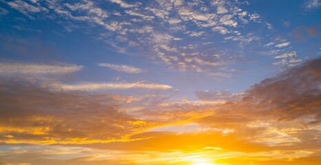 Obraz premium Sky at sunset. Sunrise over horizon. Sunset through clouds on sky. Twilight sky with sunset colors. Peaceful dawn with soft light. Dramatic dusk sunset with clouds. Sunshine in clear sky.