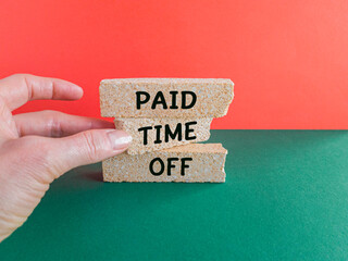 Concept words Paid Time Off on brick blocks. Beautiful red background, green table Businessman...