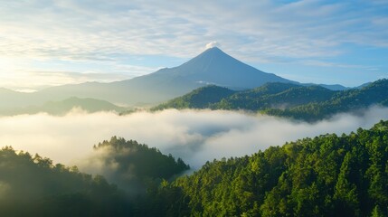 Naklejka premium A stunning mountain landscape with a volcano shrouded in mist, surrounded by lush green forests and a beautiful sky.