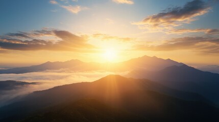 Obraz premium A breathtaking sunrise illuminates a mountain landscape, casting golden rays over mist-covered valleys and creating a serene and tranquil scene.