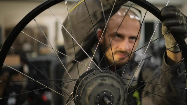 A bicycle master repairs and balances a bicycle wheel. Bicycle service.