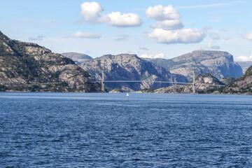 Fototapeta premium A bridge spans a body of water with mountains in the background in Norway fjord land