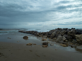 Seascape: Waves crashing against rocks under a cloudy sky. Moody and serene, capturing nature's raw power and coastal beauty.