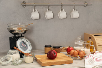 Retro mechanical kitchen scale and different food products on wooden countertop indoors