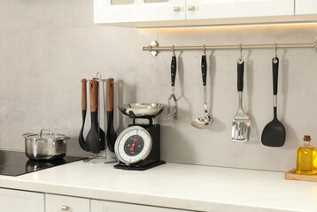 Retro mechanical kitchen scale on white marble table and other utensils indoors