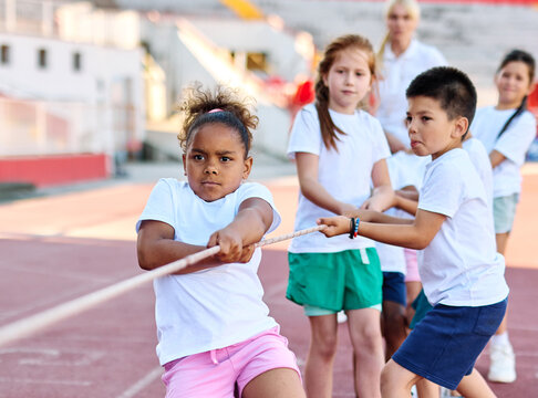 child sport exercise athlete rope competition strength challenge teamwork effort pulling pull tug rivalry struggle war conflict power contest team fun