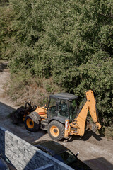 An orange tractor collects sand left over from construction, Marki, Poland.