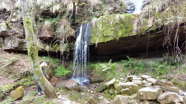 Woman hiking near waterfall in esles, cantabria