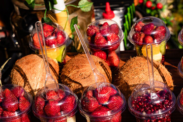 Fresh fruit cups with strawberries, coconut, and pomegranate. A natural drink packed with vitamins...