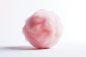 Fototapeta premium A fluffy, pink, amorphous mass resembling a cloud or cotton candy, rests on a white background.