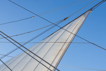 Close-up of rope and sail on a sailboat with blue sky background