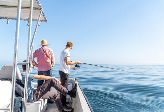 Three men fishing from a boat on the open sea