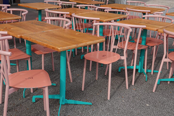 Empty outdoor restaurant tables waiting for customers, set in a peaceful urban environment.