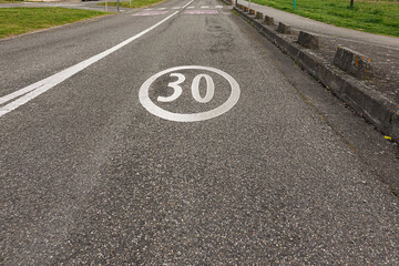 Fototapeta premium Speed limit sign indicating 30 km/h on a quiet road in a residential area