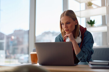 Female student e-learning on computer at university.