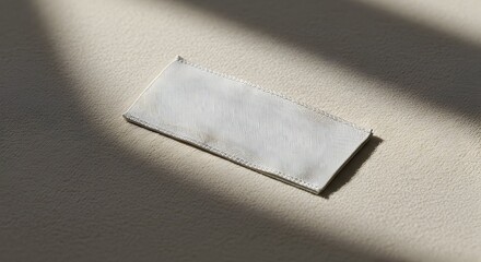 Blank Clothing Label on Fabric Surface with Shadow for Brand Mockup