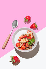 Natural Greek yogurt with chocolate granola, strawberries and banana in a bowl