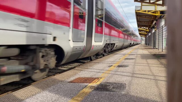 Italy , Florence, March 31st  2025- Frecciarossa Trenitalia Hight speed 300km h train railway view from a station  the faster way to travel in Italy from Milan to Rome. A1 motorway , cars and train