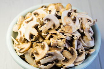 Fresh sliced champignon mushrooms in a large bowl