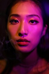 Fototapeta premium A close-up portrait of a woman with striking makeup and colorful lighting