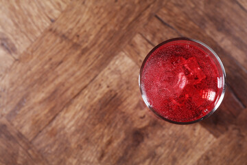 Sweet soda water with ice cubes in glass on wooden table, top view. Space for text