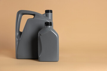 Two grey plastic canisters on beige background, space for text