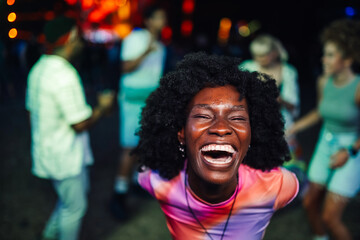 Joyful woman laughing at vibrant outdoor party