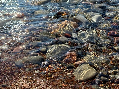 Pebbles and stones in clear sea water.
