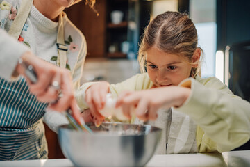 Young girl learning to bake with guidance