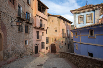 Colorful stone street with rustic houses, old windows and scenic light at sunset in the village of Albarracin