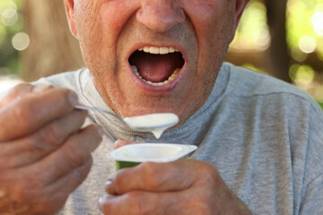mouth of an elderly man eating yogurt