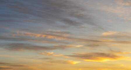 Serene sunset sky with soft clouds and gentle golden hues