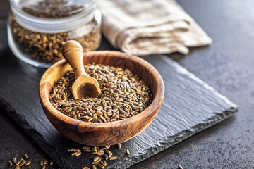 Milk thistle seeds in bowl on black table.