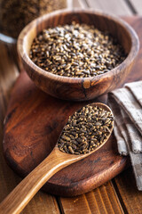 Milk thistle seeds on wooden spoon on wooden table.