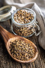 Milk thistle seeds on wooden spoon on wooden table.