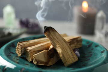 Smoldering palo santo stick on table, closeup