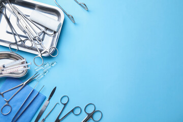 Different surgical tools on light blue background, flat lay. Space for text