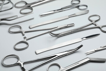 Different surgical tools on light gray background, closeup