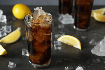 Fresh iced cola and lemon slices on dark grey table, closeup. Space for text